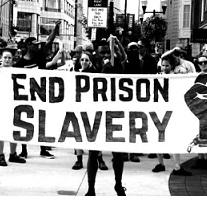 Black and white photo of people holding a sign outside in a protest that says End Prison Slavery