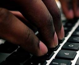 Close up of someone's fingers typing on a computer keyboard