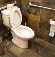 White toilet with lid up and toilet paper roll on hanger on wall under a silver bar against a brown tile wall and floor