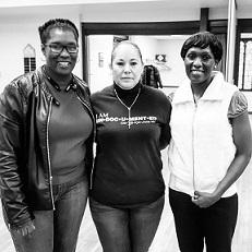 Black and white photo of three women, two black and one Latina smiling at the camera