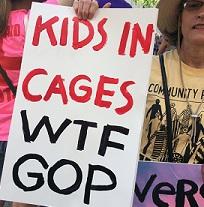 Woman holding sign saying Kids in Cages WTF GOP