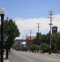 Street scene with a tower and trees and a lightpost and electricity poles