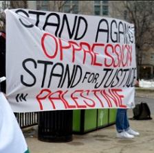 A big sign on a sheet saying Stand Against Oppression Stand for Justice for Palestine