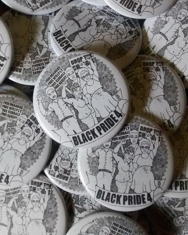 Pile of white and black buttons with drawing of four black kids raising fists on them