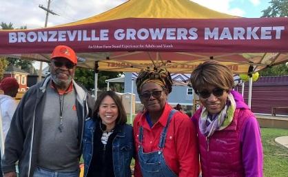 People posing in front of Bronzeville Growers Market booth