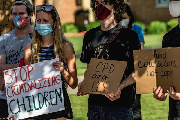 People holding signs saying Stop Criminalizing Children