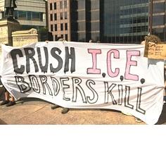 People at rally holding banner reading Crush ICE borders kill