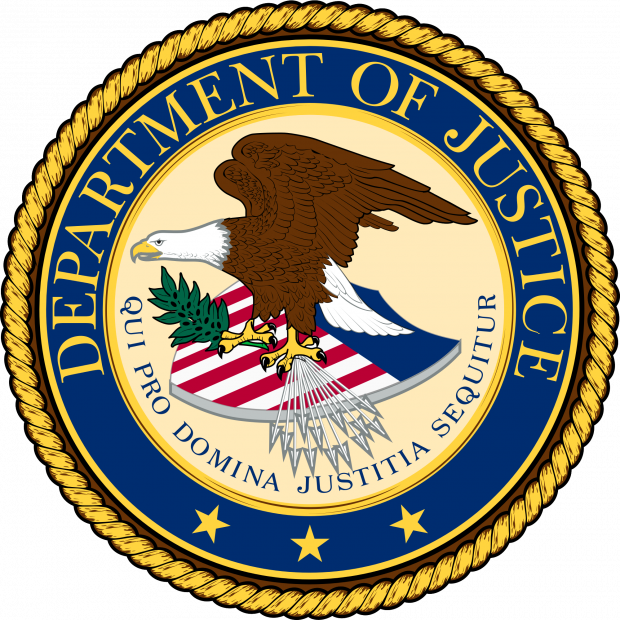Round official seal with gold braided outside rim and blue around the circle that has words Department of Justice and an eagle facing left with wings held high on top of a shield with flag colors red, white and blue, 
