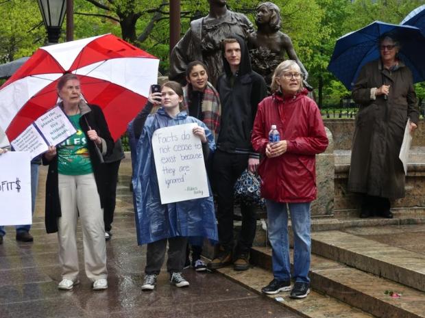 People in rain with signs touting the importance of facts