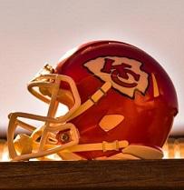 Red football helmet with a YC logo on the side sitting sideways on a wood table