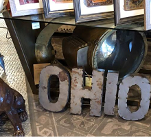 A bunch of photos on a shelf and the word Ohio cut out of metal on the floor