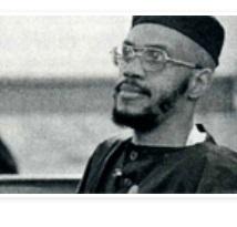Black and white photo of black man in muslim outfit, glasses and a beard