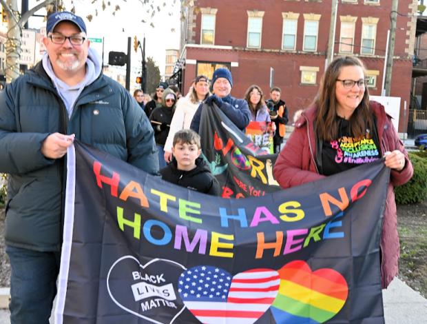 People marching with banner saying Hate has no home here