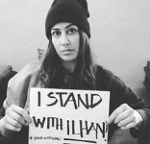 Black and white photo of woman holding small sign saying I Stand with Ilhan