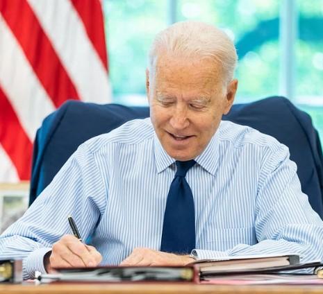 Joe Biden at desk signing something