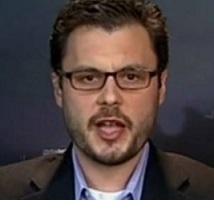 Young white man with brown-rimmed glasses with mustache and goatee talking to the camera 