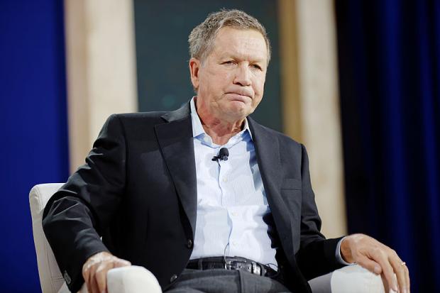 Kasich sitting and making a face