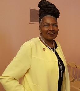 Black woman with updo wearing a yellow suit