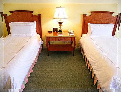 Two single beds separated in a bedroom
