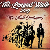Silhouettes of native people walking with flags and the words The Longest Walk 2019 We Shall Continue