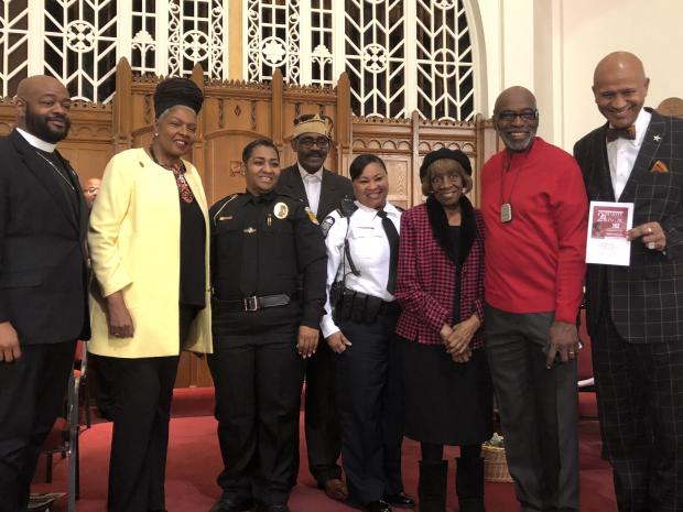 Several black men and women posing at a church 