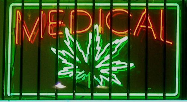 Neon sign glowing in window orange letters saying Medical and Green image of a marijuana leaf