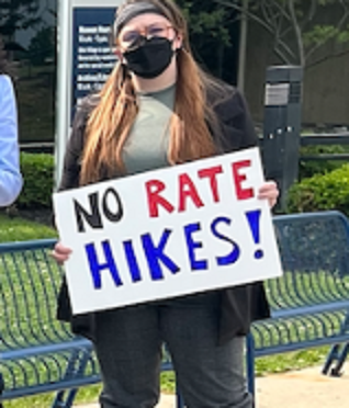 Woman holding No Rate Hikes sign