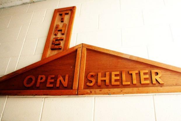 Wooden sign saying The Open Shelter