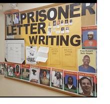 Bulletin board on the wall with words Prisoner Letter Writing and photos of a lot of men