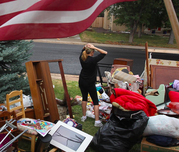 Woman outside in a yard full of furniture after eviction