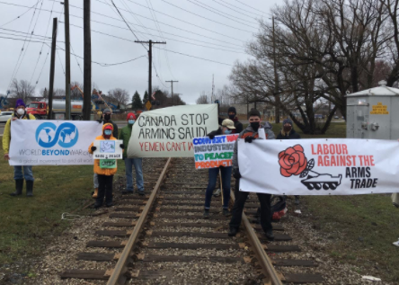 People holding signs on a railroad track