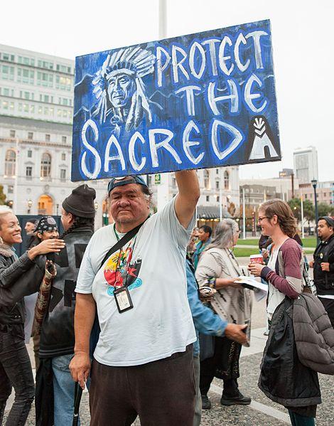 Native man holding sign about Standing Rock