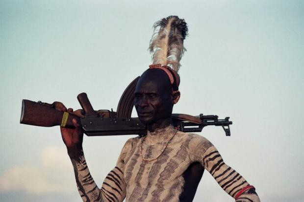 Photos of indigenous man with rifle 