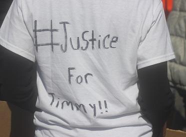 The back of a person wearing a white T-shirt that says Justice for Timmy!!
