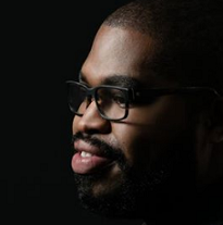 Black man's face looking left with glasses and a goatee