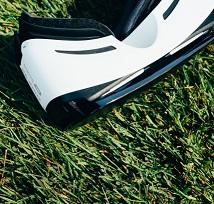 White and black virtual reality goggles laying on grass