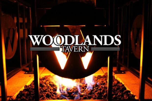 Fire in stove behind words Woodlands Tavern