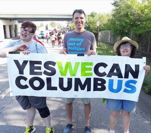 People outside holding a Yes We Can banner