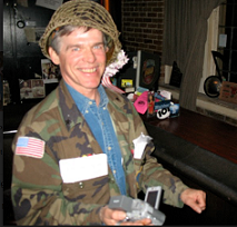 White man with a helmet on a big smile, and a camouflage jacket