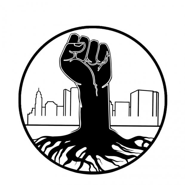 Black fist rising up from the ground like a tree with Columbus scene in the background