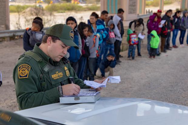 Border patrol and line of immigrants