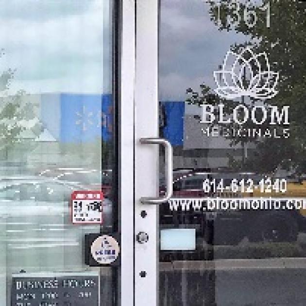 Glass front door of business with words Bloom Medicinals