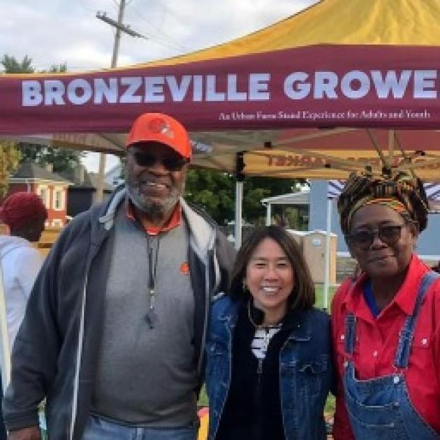 People posing in front of Bronzeville Growers Market booth