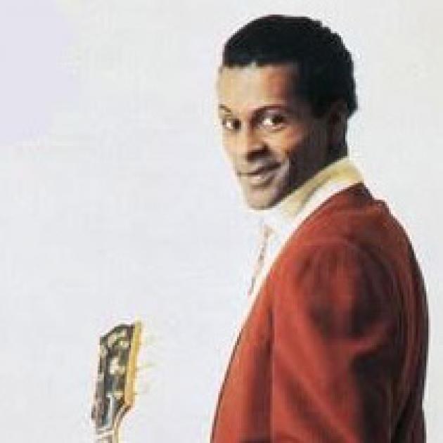 Black man in red suit holding a guitar