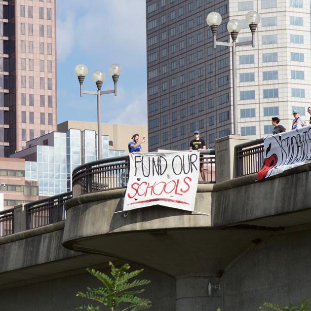 Fund Schools sign hung on overpass