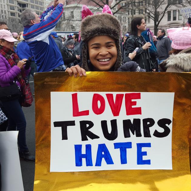 Young woman holding Love Trumps Hate sign