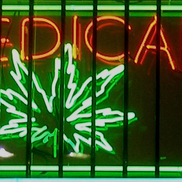 Neon sign glowing in window orange letters saying Medical and Green image of a marijuana leaf