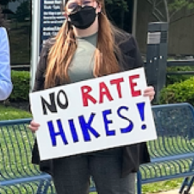 Woman holding No Rate Hikes sign