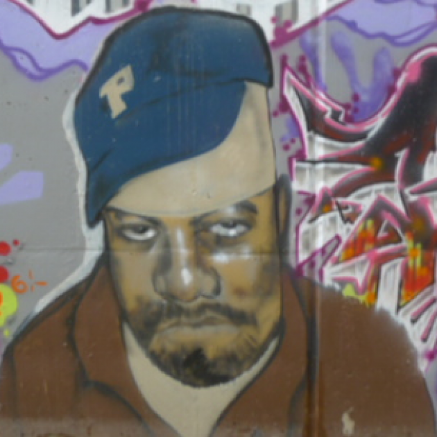 A black man wearing a blue baseball cap looking sad