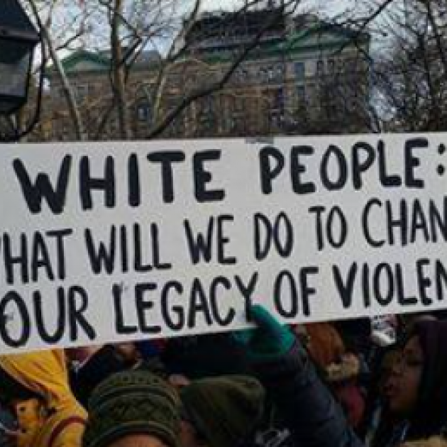 Banner saying White People What will we do to change our legacy of violence